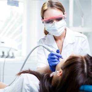 Female patient getting her teeth cleaned by a female hygienist