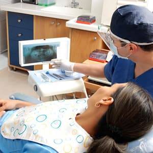 Male dentist showing digital x-rays to a female patient