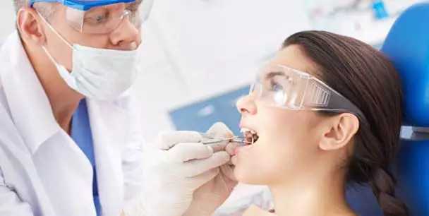 Male dentist examining a female patient's teeth