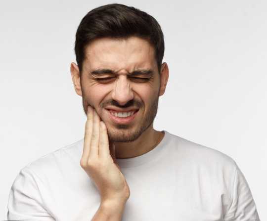 Man holding head from TMJ pain