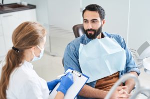 dentist speaking to patient in dental chair